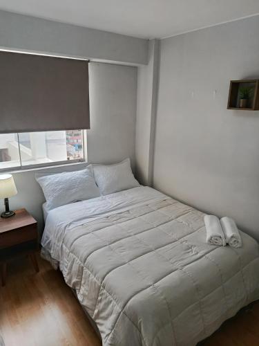 a bedroom with a large bed with a window at Miraflores View in Lima