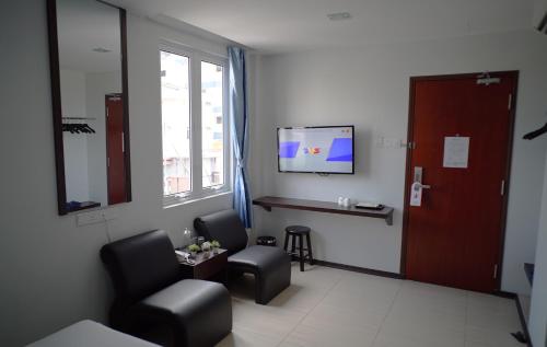 a waiting room with two chairs and a flat screen tv at Hotel Cascada in Kota Tinggi