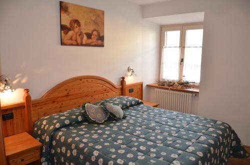 a bedroom with a bed with a blue comforter at Residence Ca' Delle Margherite in Pellizzano