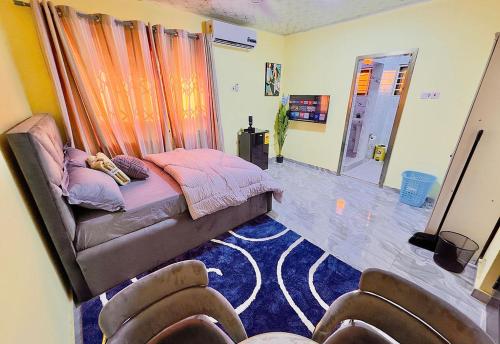 a bedroom with a bed and two chairs at Villa de chez nous in North Legon