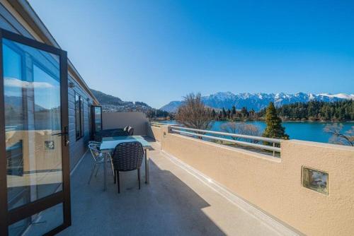 a balcony of a house with a table and chairs at Lakefront Luxury Penthouse central Queenstown in Queenstown