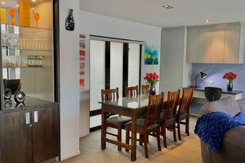 a dining room and kitchen with a table and chairs at Lakefront Luxury Penthouse central Queenstown in Queenstown