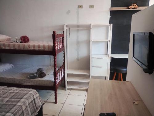 a bedroom with two bunk beds and a tv at kitnet08 para 04 pessoas bem localizada garagem in Ourinhos