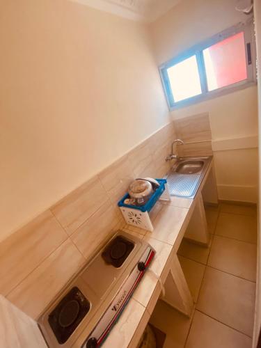 una piccola cucina con un bancone e un lavandino di Bethany Hotel a Abidjan