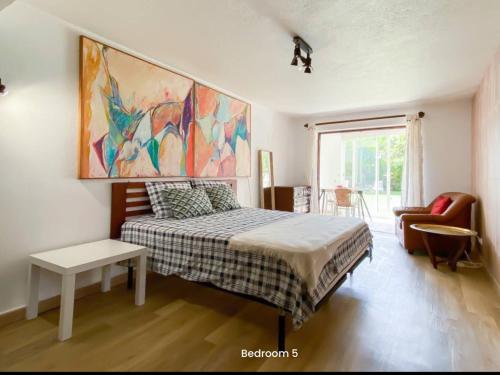 a bedroom with a bed and a painting on the wall at 5minutos do jardim até ao mar in Parede