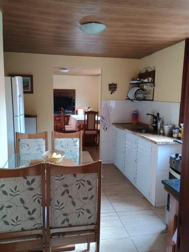 a kitchen with a table and chairs in a room at Hospedagem do Rio in Nova Friburgo