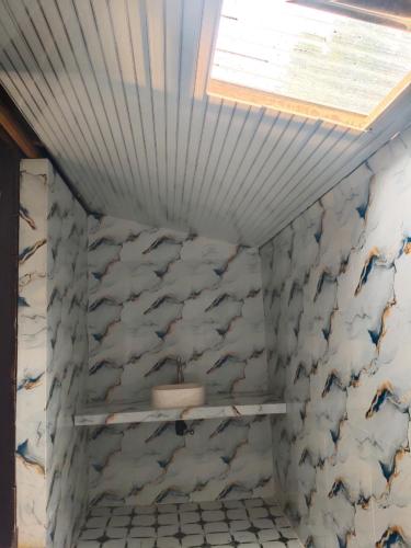 a bathroom with a sink and a wall covered in marble at Djambu Tree Homestay in Biha