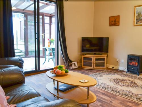 a living room with a couch and a table at Ashley Cottage in Bowmore