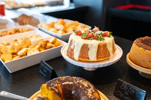 a table with different types of cakes and other desserts at Vektor Itabirito in Itabirito