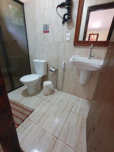 a bathroom with a toilet and a sink at Sossego Da Mata in Santo Antônio do Leite