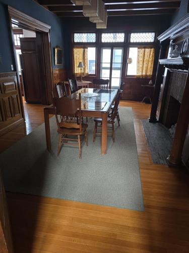 a dining room with a table and chairs on a rug at Summer Street Guest House in Buffalo