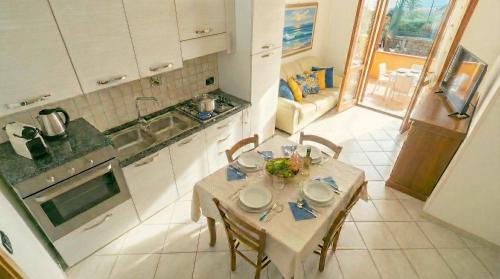 a kitchen with a table and chairs and a kitchen with a table and a table at Cavour Apartment With Terrace in Palau