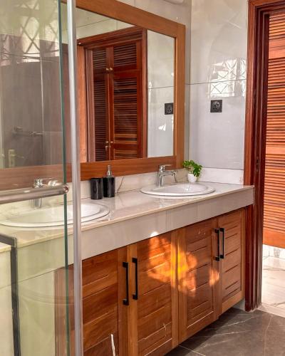a bathroom with two sinks and a mirror at Uttoru Creek Villa-2 in Mombasa