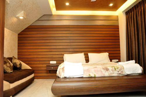 a bedroom with a bed and a wooden wall at Hotel Great Western in Kolkata