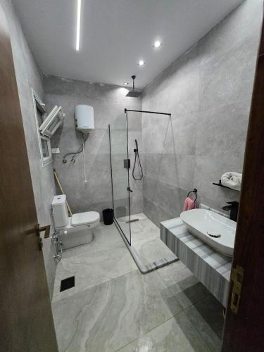 a bathroom with a shower and a toilet and a sink at رويال جاردن سويت in Cairo