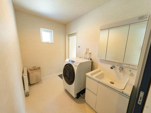 a bathroom with a sink and a washing machine at torinuma VILLA in Furano
