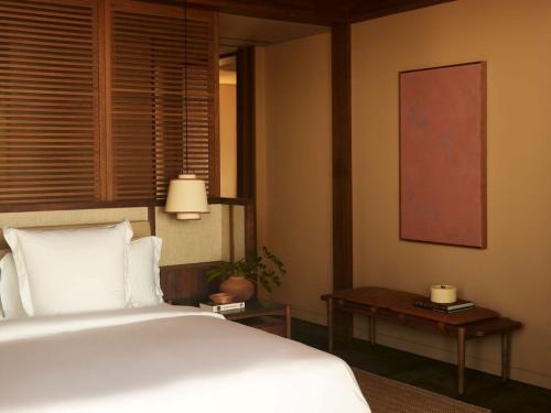 a bedroom with a large white bed and a table at Rosewood Mandarina in Monteón