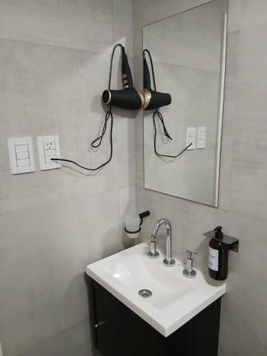 a bathroom with a sink and a hair dryer on the wall at zona balcarce in Salta