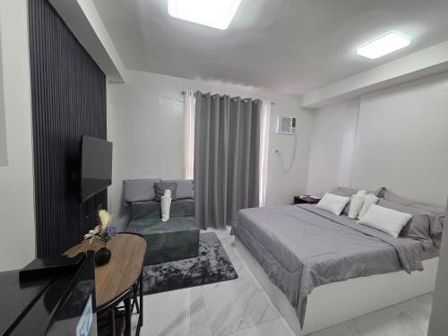 a bedroom with two beds and a desk and a television at Gem's Silid Tulugan in Cebu City