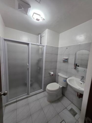 a bathroom with a shower and a toilet and a sink at Gem's Silid Tulugan in Cebu City