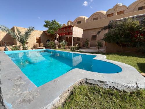 una piscina davanti a una casa di Agpeninshal Ecolodge a Siwa
