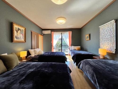 a room with three beds and a couch at Beachfront Irori in Suo Oshima