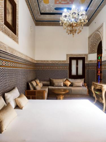 a bedroom with a bed and a chandelier at Riad Benkirane Fes Medina in Fez
