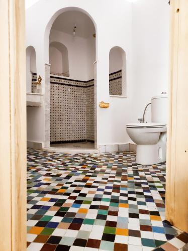 a bathroom with a checkered floor and a toilet at Riad Benkirane Fes Medina in Fez
