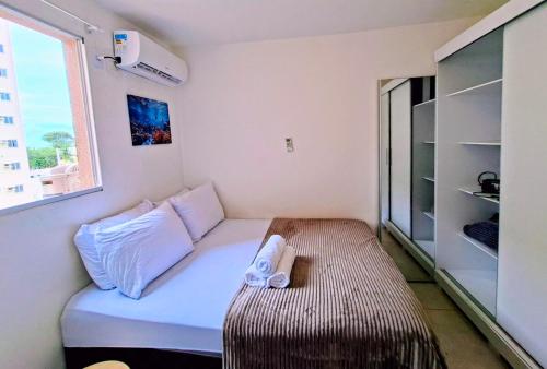 a small room with a bed and a window at Apartamento 2 Quartos com Piscina e Garagem in Maceió