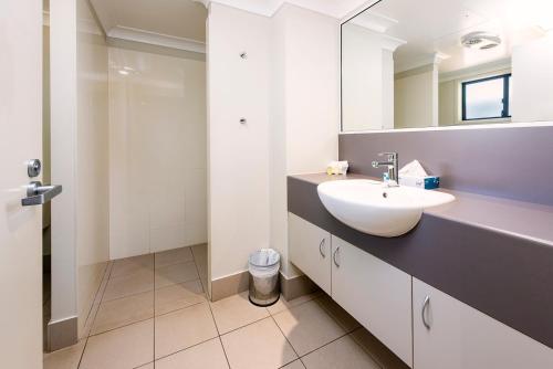 a white bathroom with a sink and a mirror at Royal Motel Miles in Miles