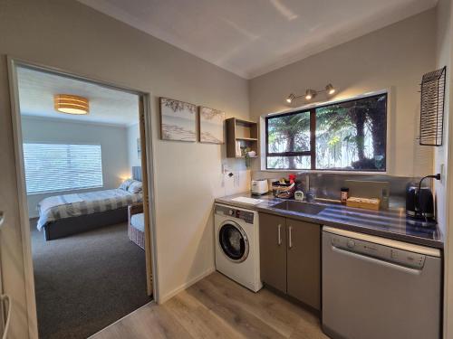 a kitchen with a sink and a washing machine at Links View Retreat in Omokoroa