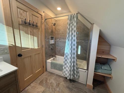 a bathroom with a shower and a bath tub at Cattail Cabin in Waterville