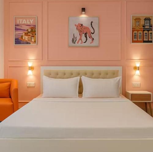a bedroom with a large white bed and an orange chair at Irida 2bhk private pool viila in Assagao