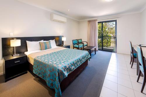 a hotel room with a bed and a balcony at Royal Motel Miles in Miles