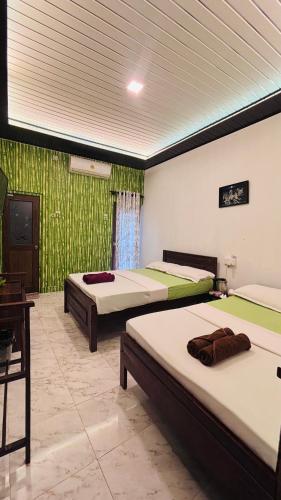 a room with two beds and a desk at Sandakada Homestay in Anuradhapura