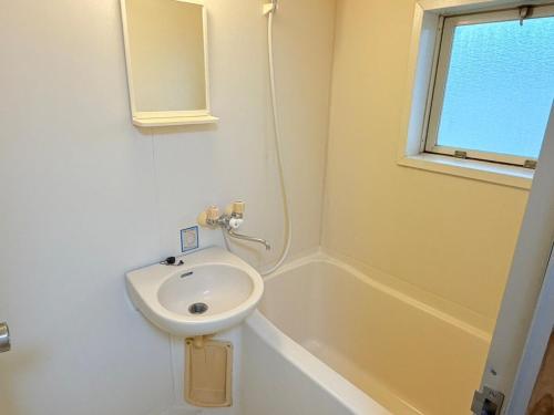 a white bathroom with a sink and a bath tub at サクセスハイム 208 in Miyazaki