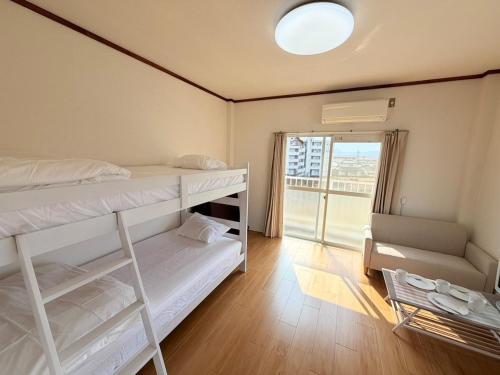 a small room with two bunk beds and a window at テラスリバーサイド 301 in Miyazaki