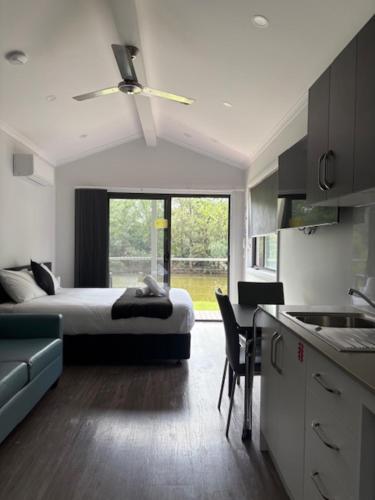a bedroom with a bed and a kitchen with a table at Denman Van Village in Denman