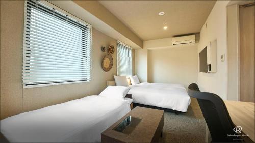 a hotel room with two beds and a table at DEL style Osaka Higashi Temma by Daiwa Roynet Hotel in Osaka