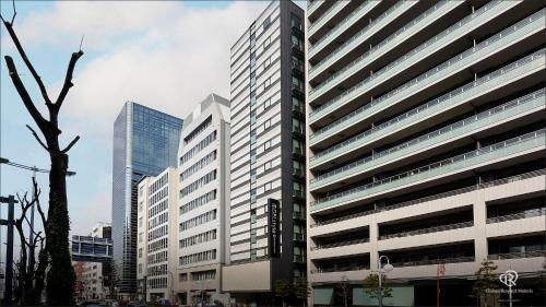 a tall building in a city with tall buildings at DEL style Osaka Higashi Temma by Daiwa Roynet Hotel in Osaka