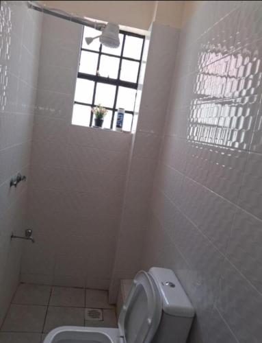 a bathroom with a toilet and a window at BoniMark in Machakos