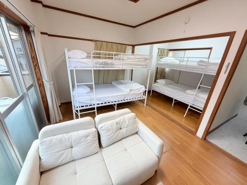 a living room with a couch and bunk beds at パームハウス 203 in Miyazaki