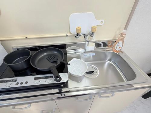a kitchen sink with pots and pans on it at パームハウス 203 in Miyazaki