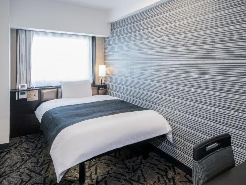 a bedroom with a large bed with a large window at APA Hotel Tokyo Ojima in Tokyo