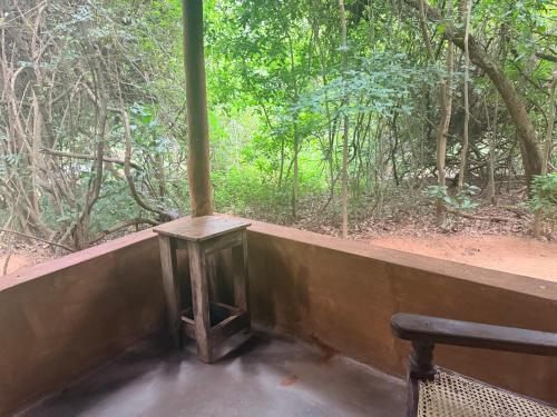 a table and a bench in front of a forest at Kamatha Eco Lodge in Habarana