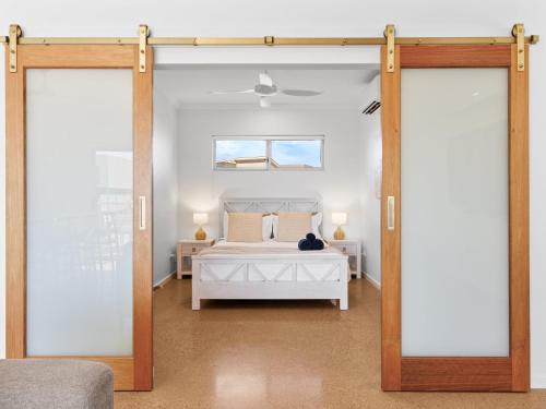 a bedroom with a white bed and a window at Exmouth Retreat - 3x3 on the canals in Exmouth