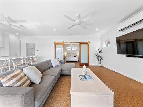 a living room with a couch and a table at Exmouth Retreat - 3x3 on the canals in Exmouth