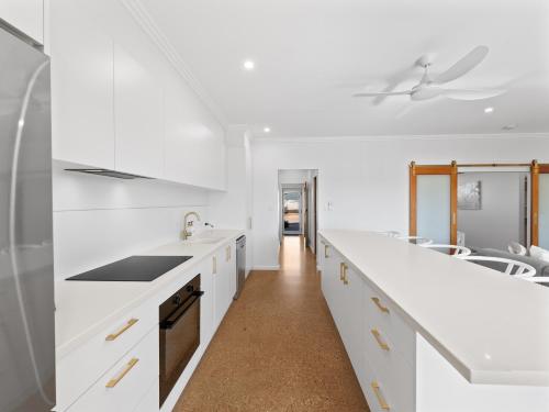 a white kitchen with white counters and white counter tops at Exmouth Retreat - 3x3 on the canals in Exmouth