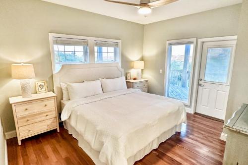 a bedroom with a white bed and two windows at FO13 Dreamcatcher in Frisco