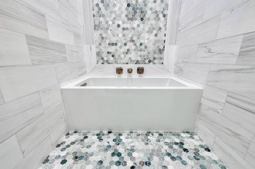 a white bath tub in a bathroom with a tiled floor at FO13 Dreamcatcher in Frisco